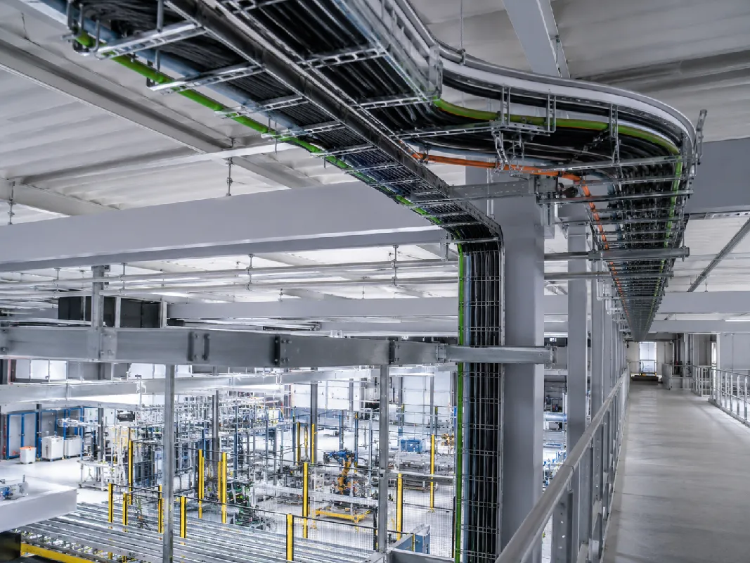 Kabeltrassen mit verlegten Leitungen in einer modernen Produktionshalle f&uuml;r industrielle Elektroinstallation